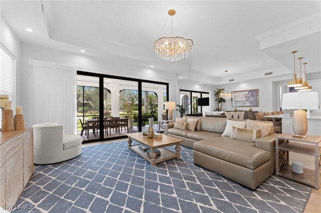living area featuring wood finished floors, a chandelier, a tray ceiling, visible vents, and recessed lighting