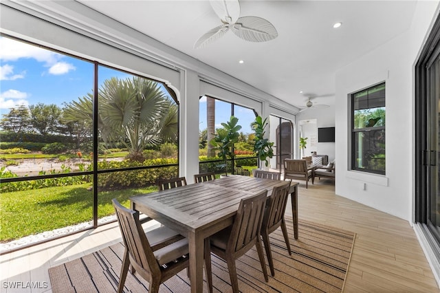 sunroom / solarium featuring wood finished floors, recessed lighting, a healthy amount of sunlight, and a deck