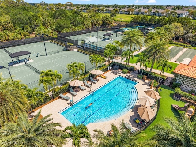 community pool with fence and a tennis court