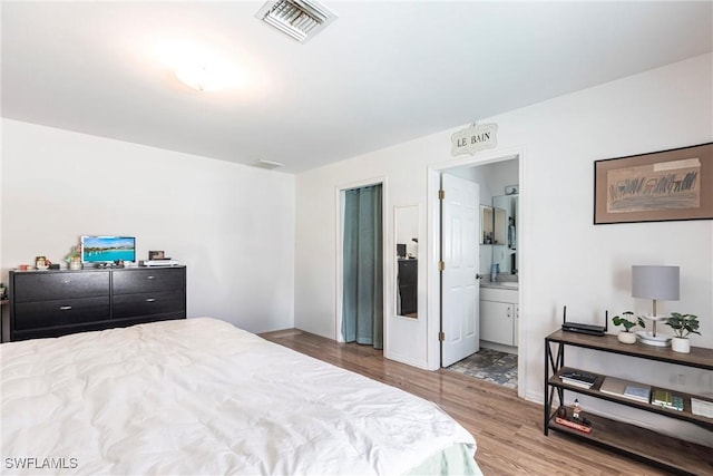 513 SE 27th Ter, Cape Coral, FL 33904 - bedroom with wood finished floors, visible vents, and connected bathroom