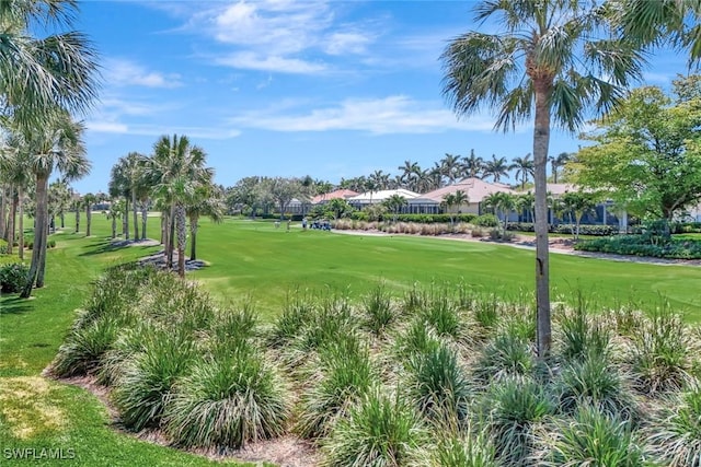 view of home's community featuring view of golf course and a lawn