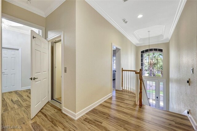 entrance foyer with crown molding, light wood-type flooring, and baseboards