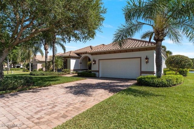 10326 Wishing Stone Ct, Bonita Springs, FL 34135 - mediterranean / spanish-style house featuring a tiled roof, stucco siding, decorative driveway, a front lawn, and a garage