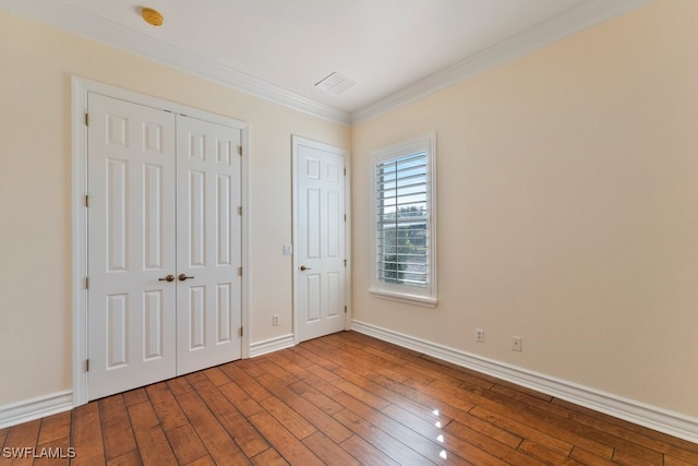 10326 Wishing Stone Ct, Bonita Springs, FL 34135 - unfurnished bedroom with crown molding, hardwood / wood-style floors, baseboards, and visible vents