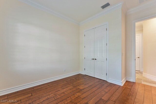 10326 Wishing Stone Ct, Bonita Springs, FL 34135 - unfurnished bedroom featuring wood-type flooring, visible vents, a closet, and ornamental molding