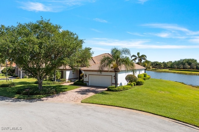 10326 Wishing Stone Ct, Bonita Springs, FL 34135 - view of front of property featuring stucco siding, a garage, a front lawn, a tile roof, and a water view