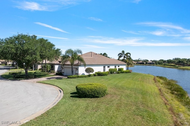 10326 Wishing Stone Ct, Bonita Springs, FL 34135 - exterior space featuring a front yard, a water view, a tiled roof, an attached garage, and stucco siding