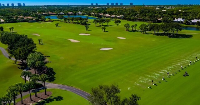 drone / aerial view featuring a city view, golf course view, and a water view