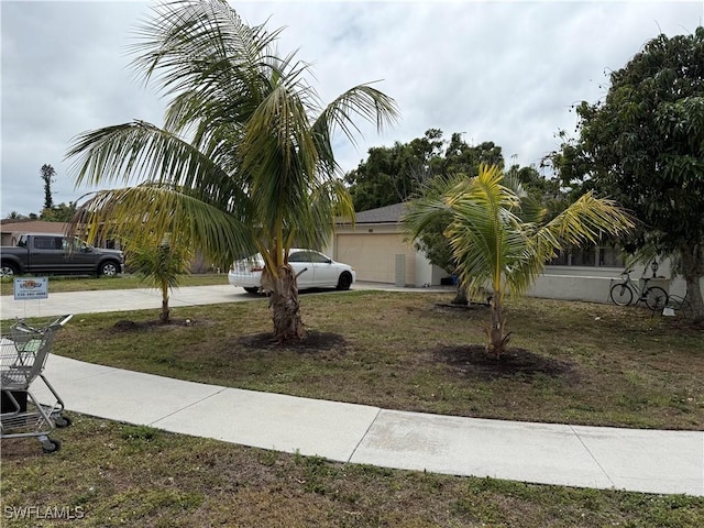 338 Melody Ct, Fort Myers, FL 33916 - view of grassy yard featuring a garage and driveway