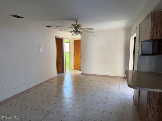 338 Melody Ct, Fort Myers, FL 33916 - spare room with a ceiling fan, light tile patterned floors, baseboards, and a textured ceiling