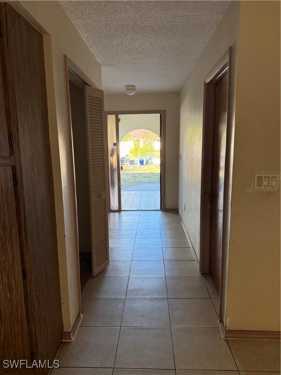 338 Melody Ct, Fort Myers, FL 33916 - hallway with a textured ceiling and light tile patterned floors