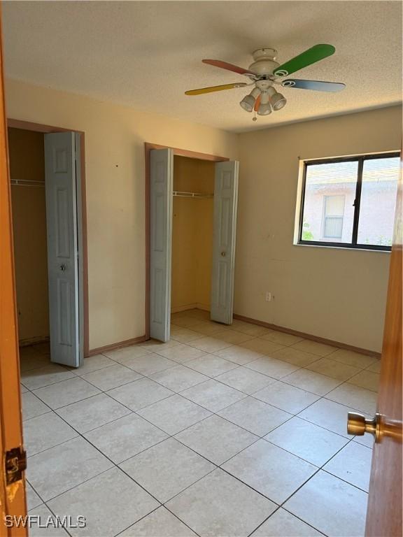 338 Melody Ct, Fort Myers, FL 33916 - unfurnished bedroom featuring light tile patterned floors, a closet, baseboards, and ceiling fan