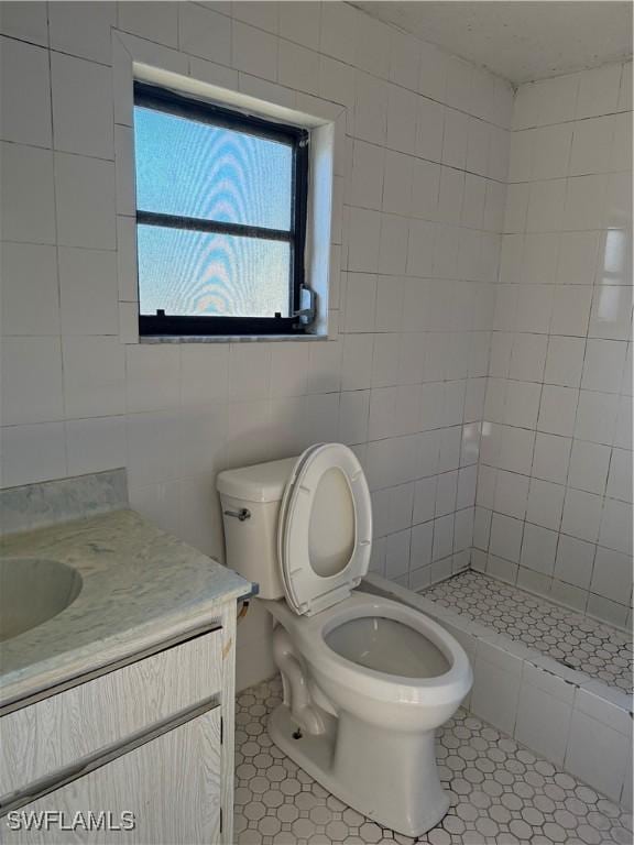 338 Melody Ct, Fort Myers, FL 33916 - bathroom with vanity, toilet, tile patterned flooring, tile walls, and a tile shower