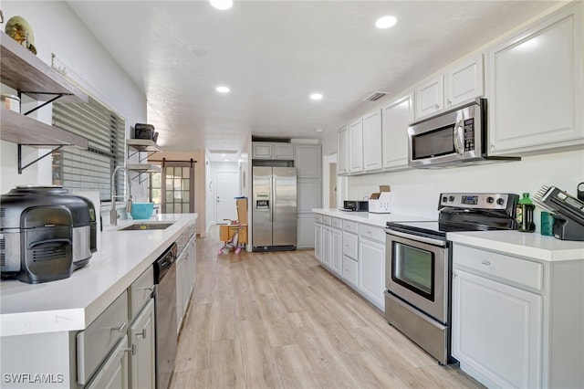 2226 SE 19th Pl, Cape Coral, FL 33990 - kitchen with open shelves, visible vents, stainless steel appliances, light wood finished floors, and a sink