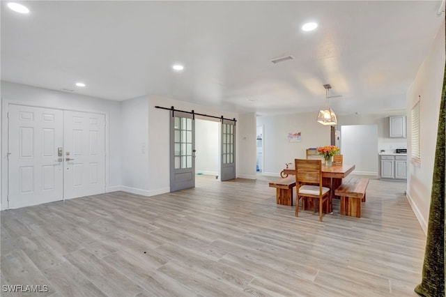 2226 SE 19th Pl, Cape Coral, FL 33990 - dining room featuring a barn door, light wood-style floors, and baseboards