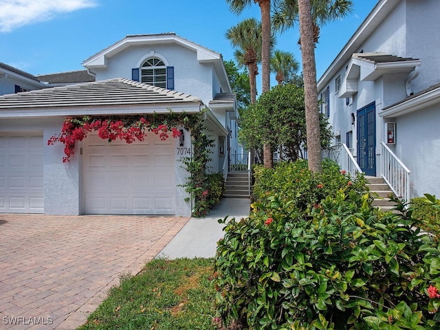 view of front of property with decorative driveway, stucco siding, and a garage