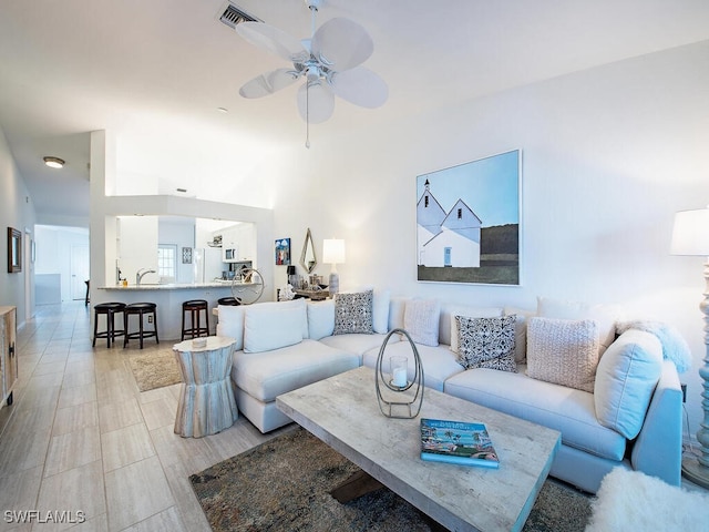 living area featuring visible vents and ceiling fan
