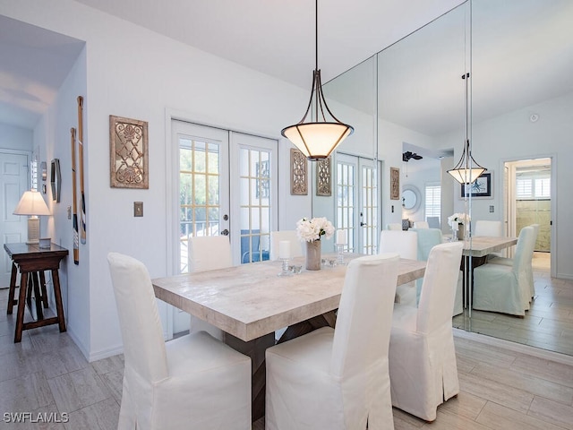 dining room featuring french doors, light wood-style floors, and baseboards