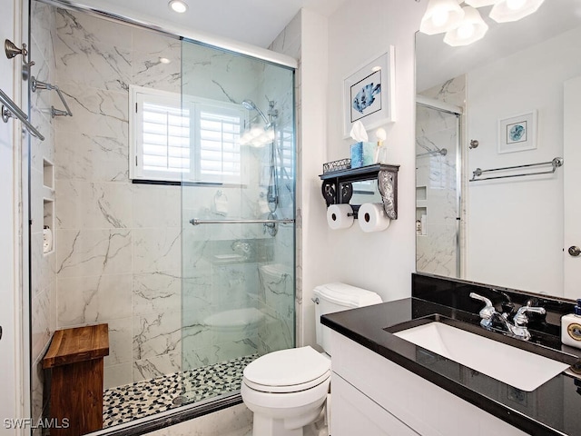 full bath featuring vanity, toilet, and a marble finish shower