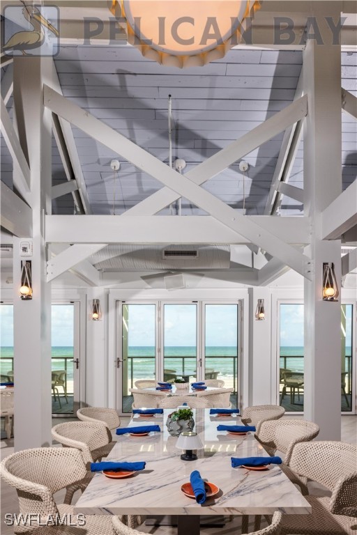 sunroom with beamed ceiling and a water view