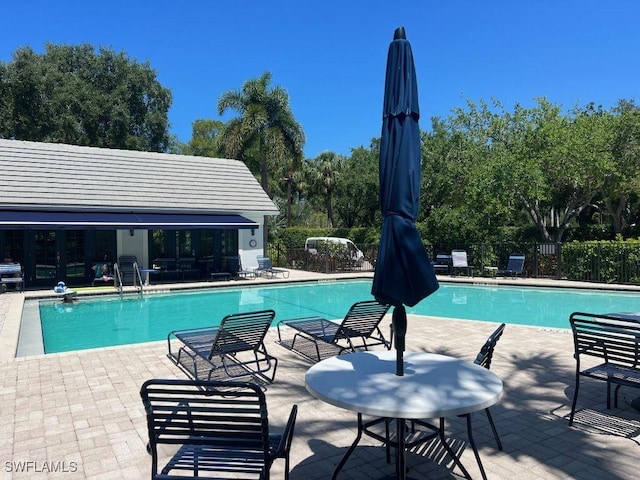 pool with fence, area for grilling, and a patio area