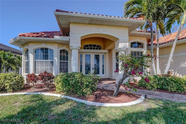 330 SW 33rd Ave, Cape Coral, FL 33991 - entrance to property with french doors, stucco siding, and a tiled roof