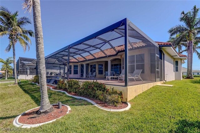 330 SW 33rd Ave, Cape Coral, FL 33991 - back of house featuring a patio, glass enclosure, stucco siding, and a lawn
