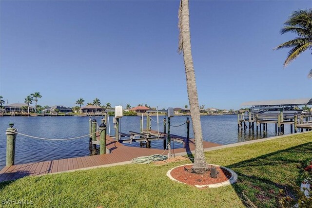 330 SW 33rd Ave, Cape Coral, FL 33991 - view of dock featuring a yard, boat lift, and a water view