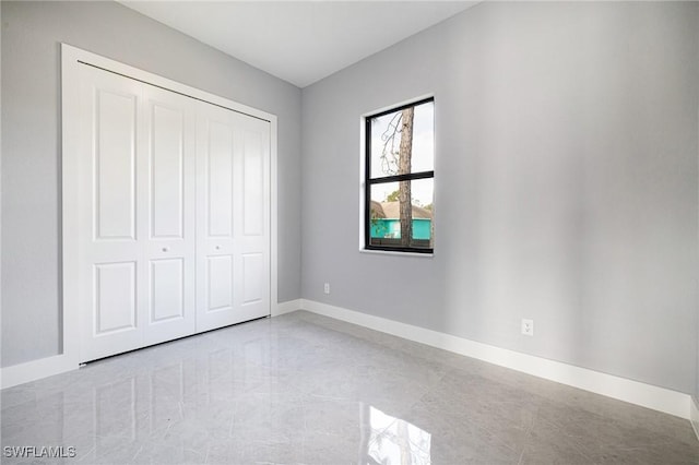 1042 Bassinger Ave S, Lehigh Acres, FL 33974 - unfurnished bedroom featuring a closet and baseboards