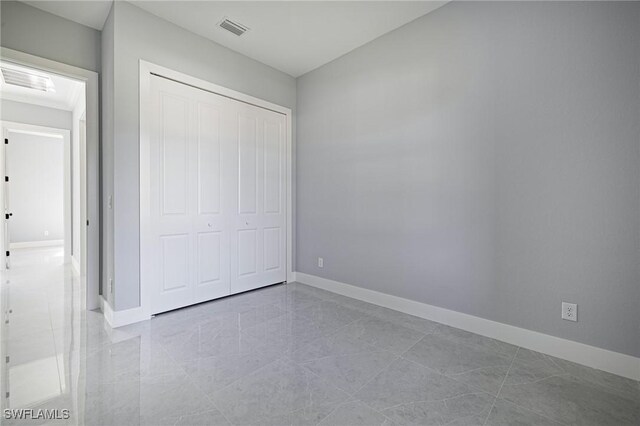 1042 Bassinger Ave S, Lehigh Acres, FL 33974 - unfurnished bedroom with visible vents, baseboards, and a closet