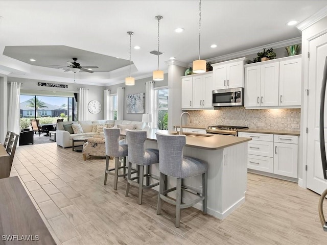 2138 Marquesa Cir, Naples, FL 34112 - kitchen featuring stainless steel appliances, ornamental molding, a sink, a ceiling fan, and a breakfast bar