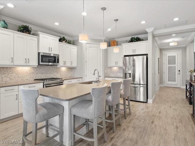 2138 Marquesa Cir, Naples, FL 34112 - kitchen with stainless steel appliances, a sink, crown molding, a kitchen island with sink, and a kitchen breakfast bar
