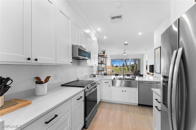 7915 Mahogany Run Ln Unit 1126, Naples, FL 34113 - kitchen with appliances with stainless steel finishes, light countertops, a ceiling fan, white cabinets, and recessed lighting
