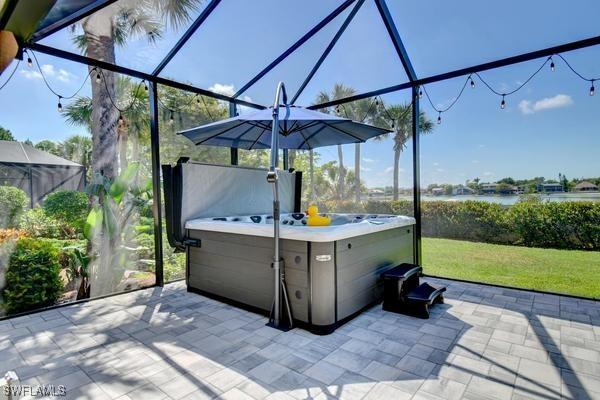 view of patio featuring a lanai and a hot tub