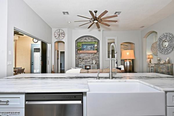 kitchen with visible vents, a sink, open floor plan, a ceiling fan, and stainless steel dishwasher