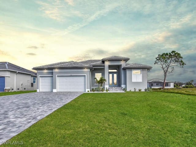 261 Rotonda Blvd S, Rotonda West, FL 33947 - prairie-style house with a front yard, decorative driveway, a garage, and stucco siding