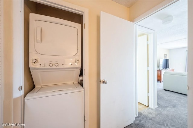 washroom featuring stacked washing machine and dryer and carpet