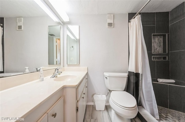 full bathroom with toilet, vanity, tiled shower, baseboards, and wood finished floors