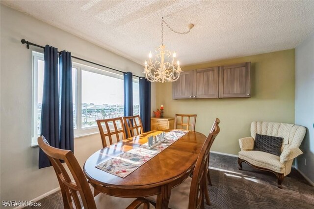 dining room with a chandelier, carpet, a textured ceiling, and baseboards