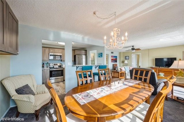 dining room featuring a chandelier, a textured ceiling, and a ceiling fan