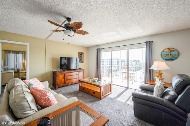 carpeted living area with a ceiling fan and a textured ceiling