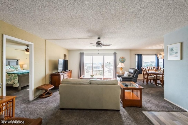 living area with a ceiling fan, carpet floors, a textured ceiling, a chandelier, and baseboards