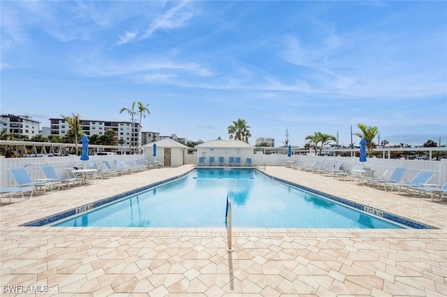community pool with fence and a patio