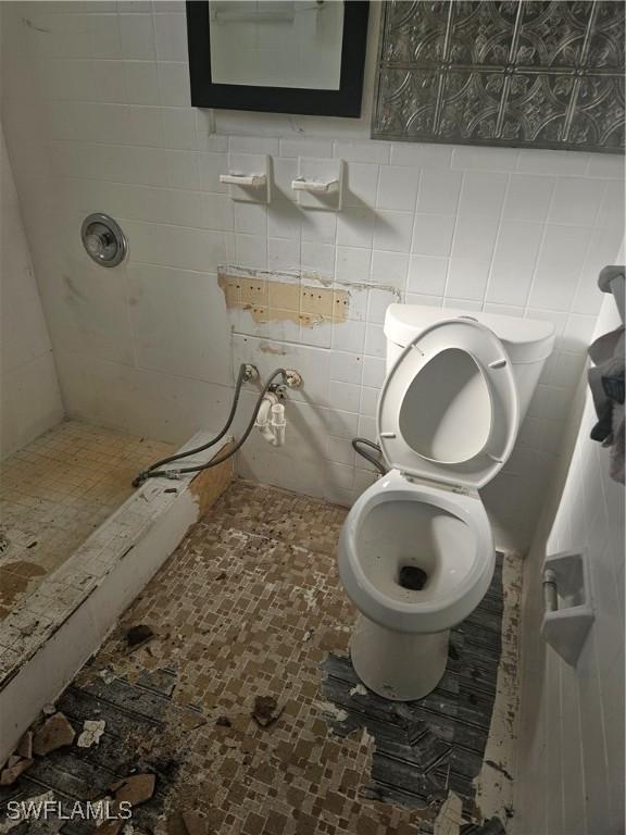 2631 Becca Ave, Naples, FL 34112 - bathroom with toilet, tile walls, and a tile shower