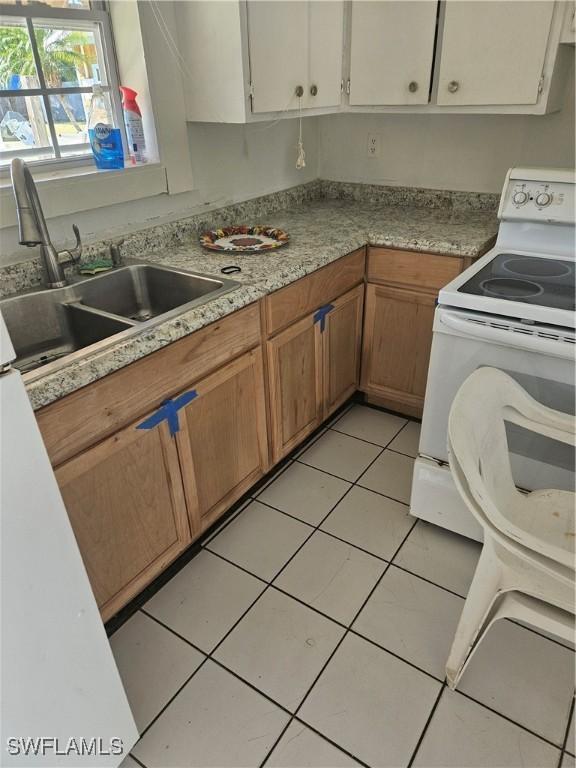 2631 Becca Ave, Naples, FL 34112 - kitchen with a sink, light countertops, white electric range, and light tile patterned flooring