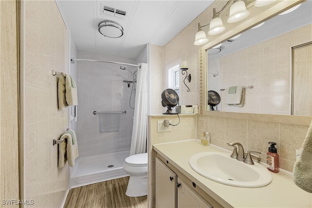 bathroom featuring a shower with shower curtain, vanity, toilet, decorative backsplash, and tile walls