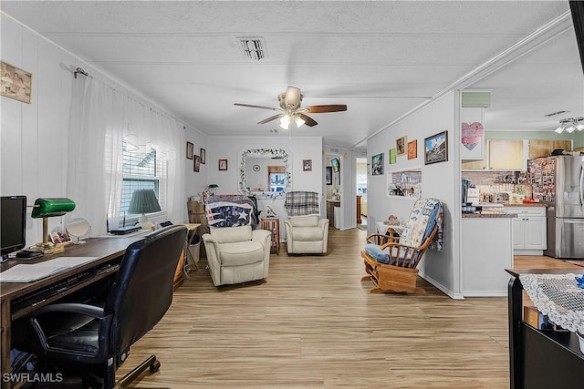 living room featuring ornamental molding, visible vents, a ceiling fan, and light wood-style floors