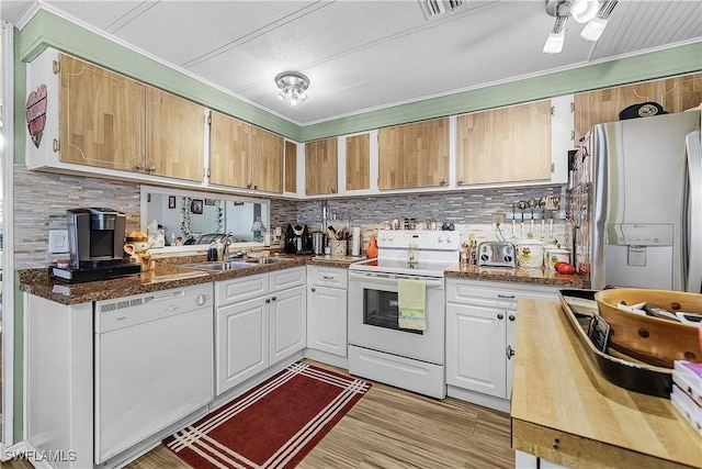 kitchen with backsplash, ornamental molding, a sink, and white appliances