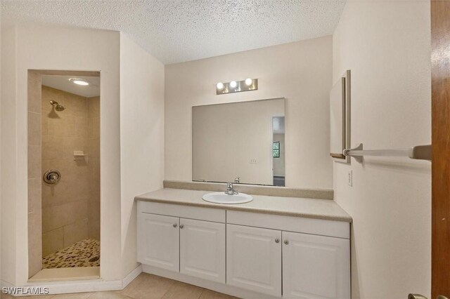 26136 Explorer Rd, Punta Gorda, FL 33983 - full bathroom with tiled shower, a textured ceiling, vanity, and tile patterned floors
