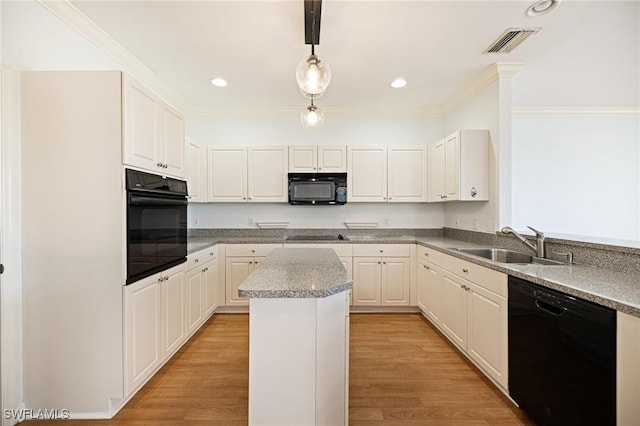 6081 Waterway Bay Dr, Fort Myers, FL 33908 - kitchen with a center island, a sink, black appliances, ornamental molding, and visible vents